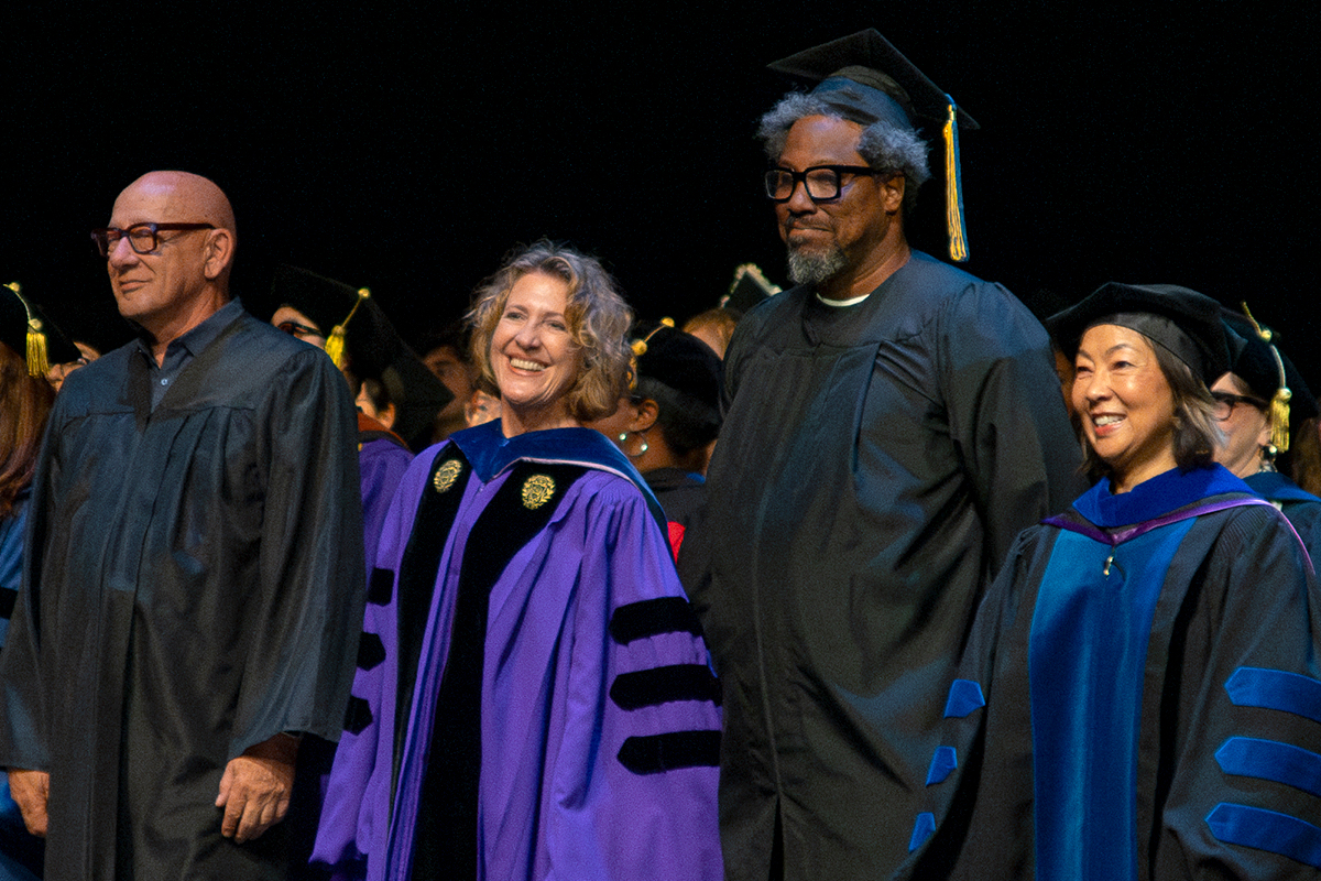 TDPS faculty members stand with commencement speaker W. Kamau Bell on the Zellerbach Playhouse stage